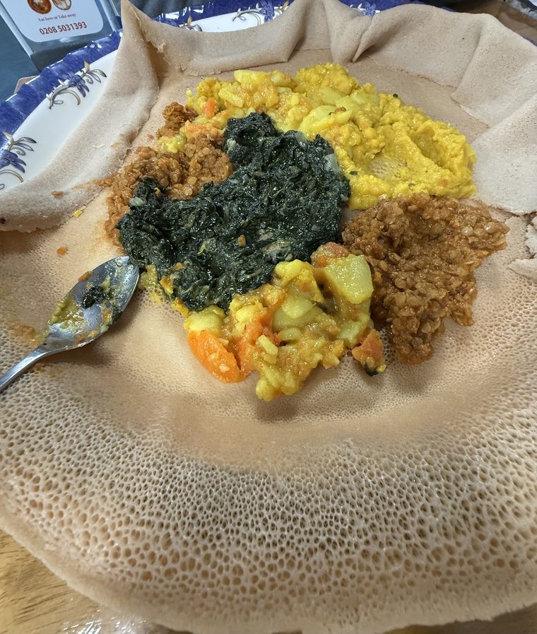 Injera with collard greens, split peas, potato and carrot, and lentils.